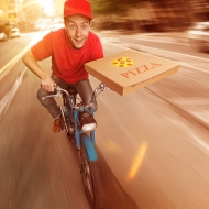 Pizzalieferant fährt Pizza auf dem Mofa aus