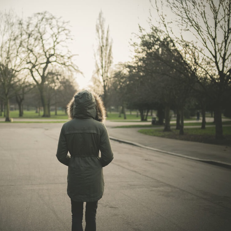 Studierende spaziert alleine im Park