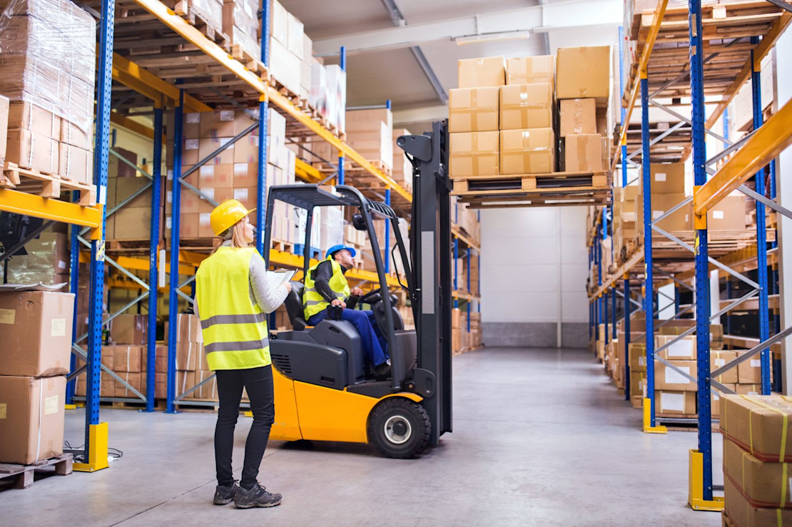 Zwei Logistikhelfer in einer Lagerhalle