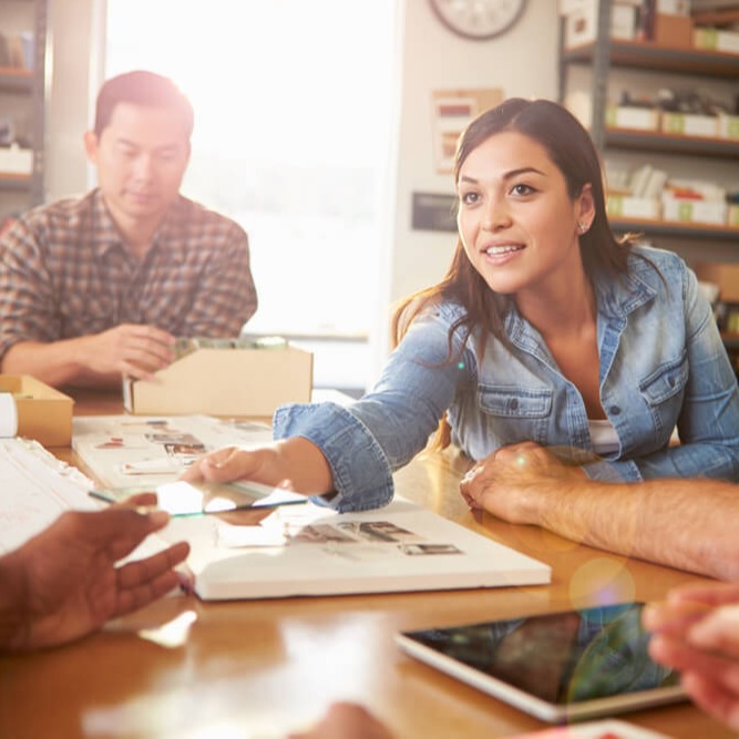 Studierende reicht etwas über den Tisch