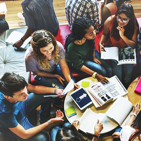 Studentische Lerngruppe sitzt zusammen am Tisch