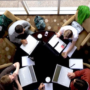 Sicht von oben auf eine Gruppenarbeit mit vier Studierenden