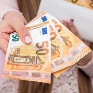 Frau hält Fünfzig Euro Scheine in die Kamera