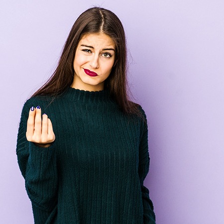 Studierende vor lila Hintergrund schaut in Richtung des Betrachters