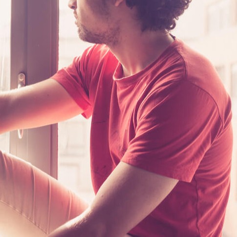 Studierender schaut frustriert aus dem Fenster