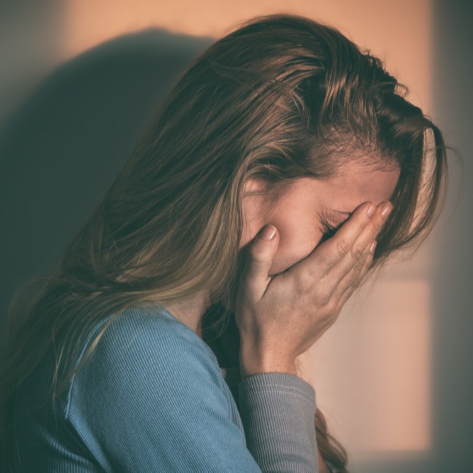 Studierende vergräbt weinend ihr Gesicht in den Händen