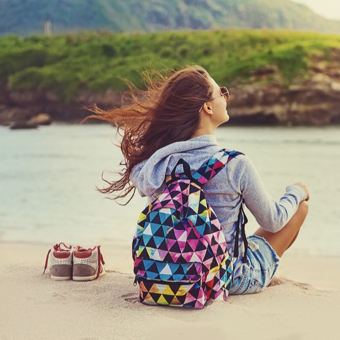 Studierende sitzt am Strand in der Karibik