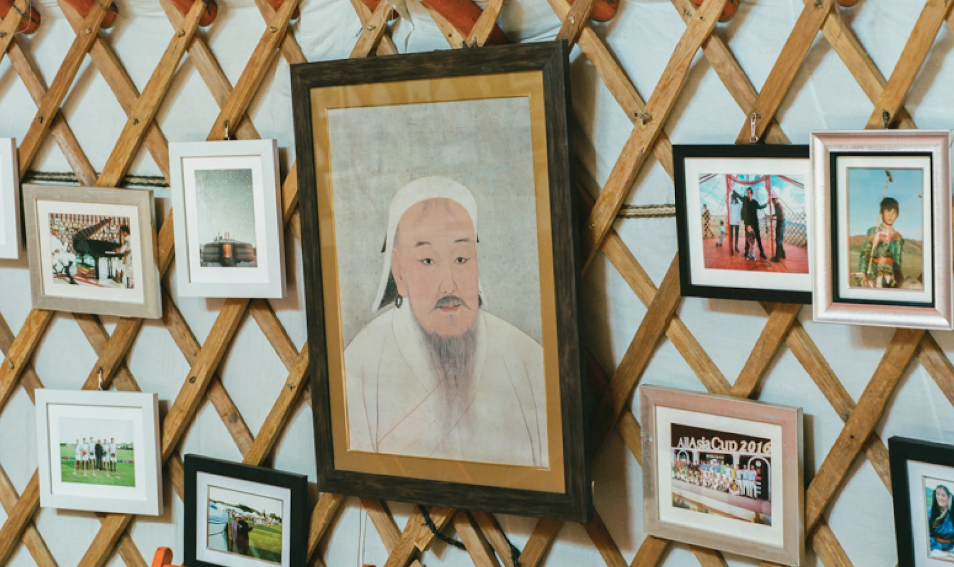 Collection of family photos and textiles hanging inside a Mongolian ger, reflecting nomadic interior life