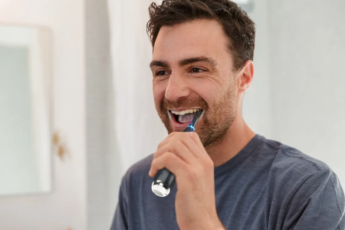 Man brushing his teeth to remove black stains article banner