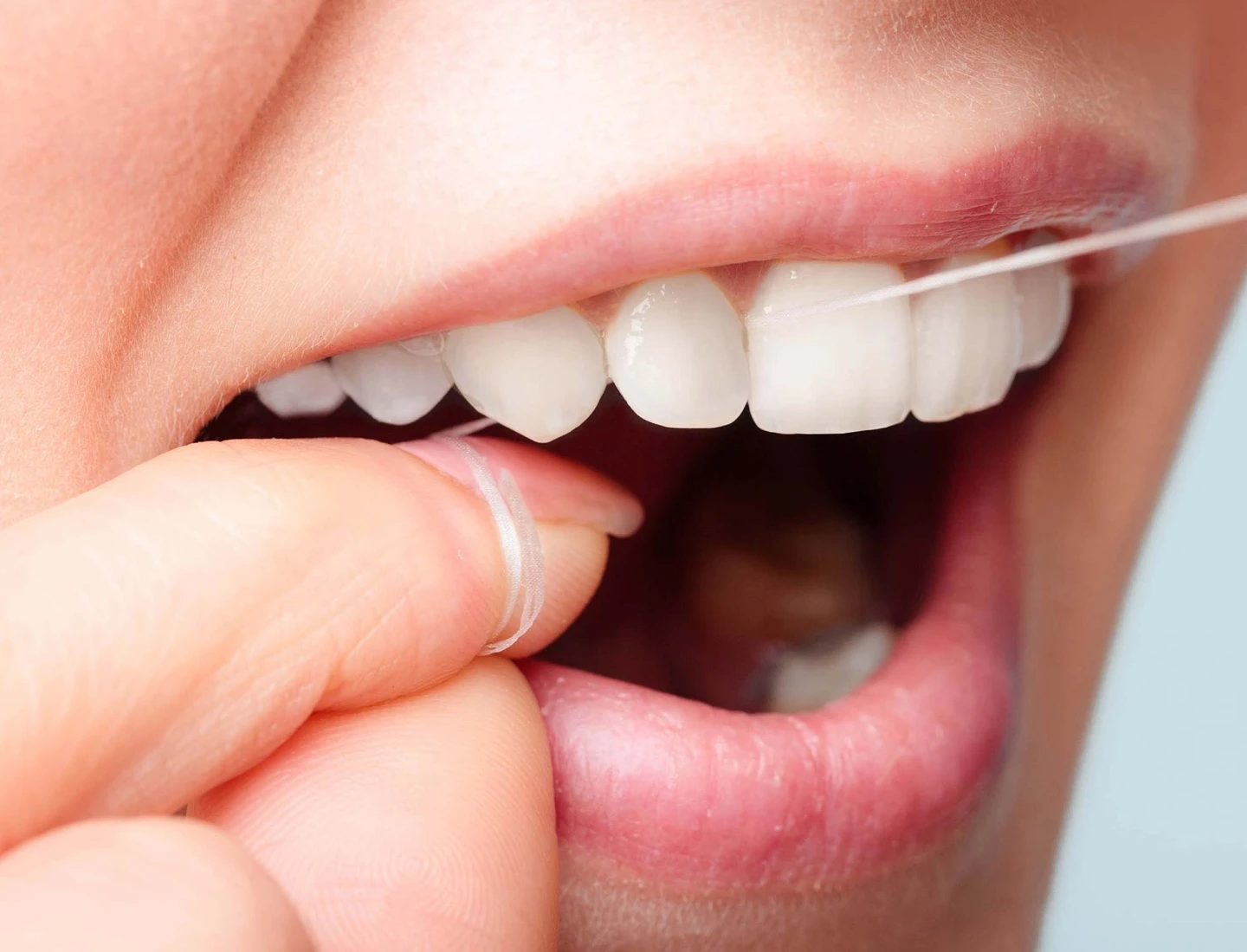 A person using an Oral-B floss