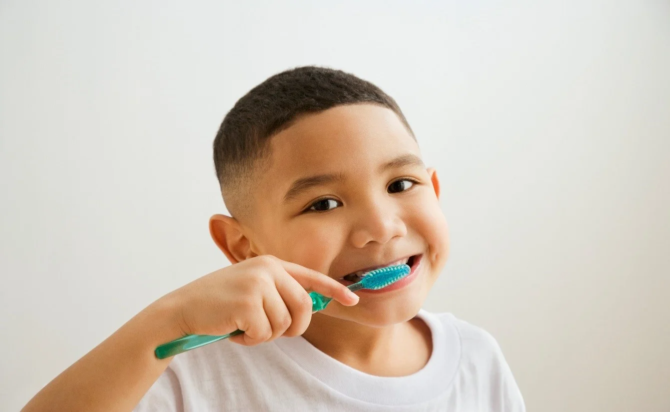Baby brushing his teeth to avoid oral thrush article banner