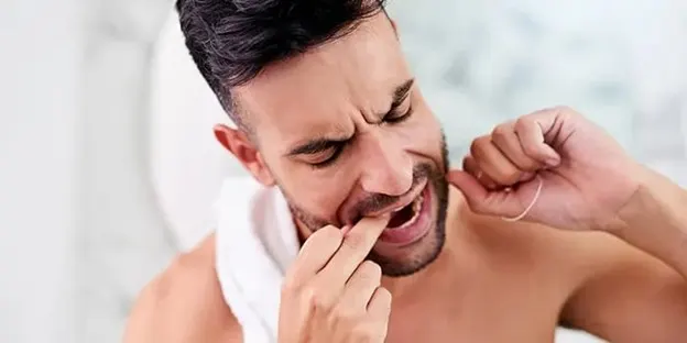 Man flossing his teeth article banner