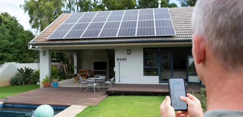 Homem a controlar com o telemóvel a potência dos painéis solares