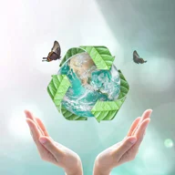 mãos abertas com simbolo de reciclagem sobre o planeta e borboletas