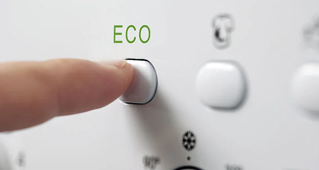 dedo a carregar no botão eco de máquina de lavar