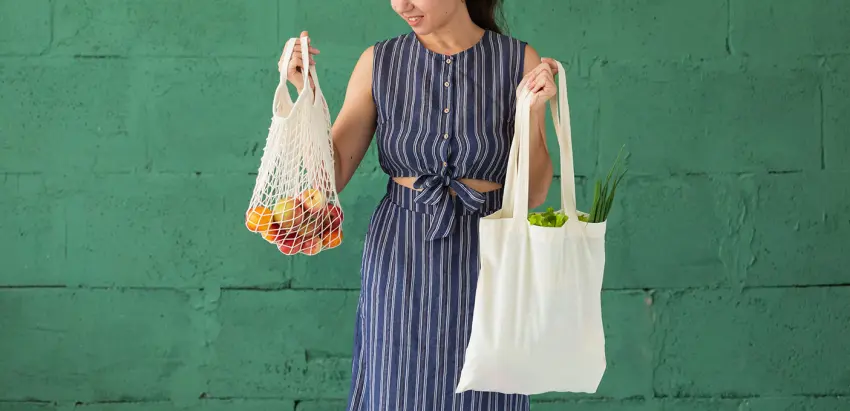 mulher com dois sacos de compras na mão