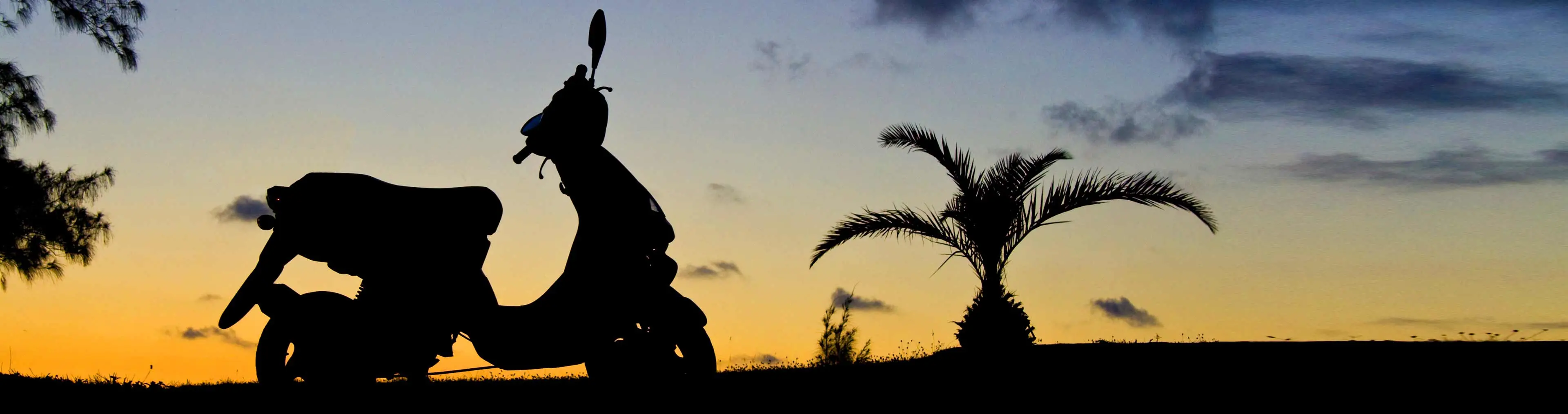 scooter parada ao pôr do sol