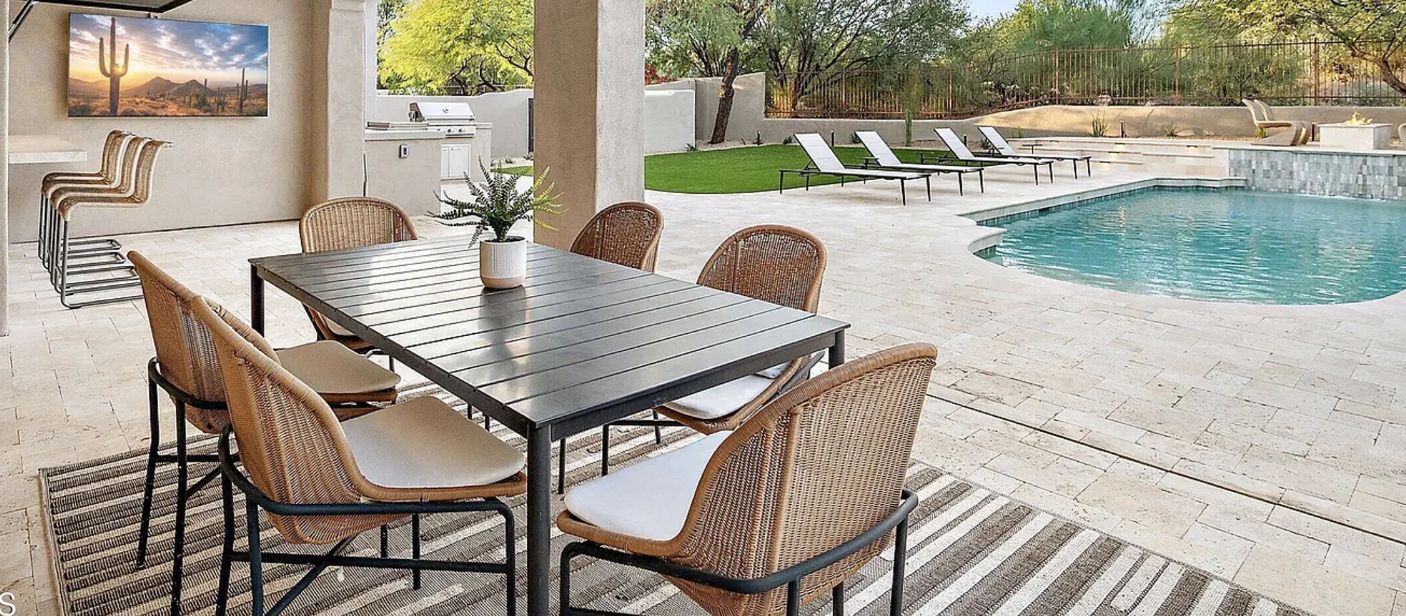 Covered terrace with an outdoor dining table next to the pool in a Phoenix home.