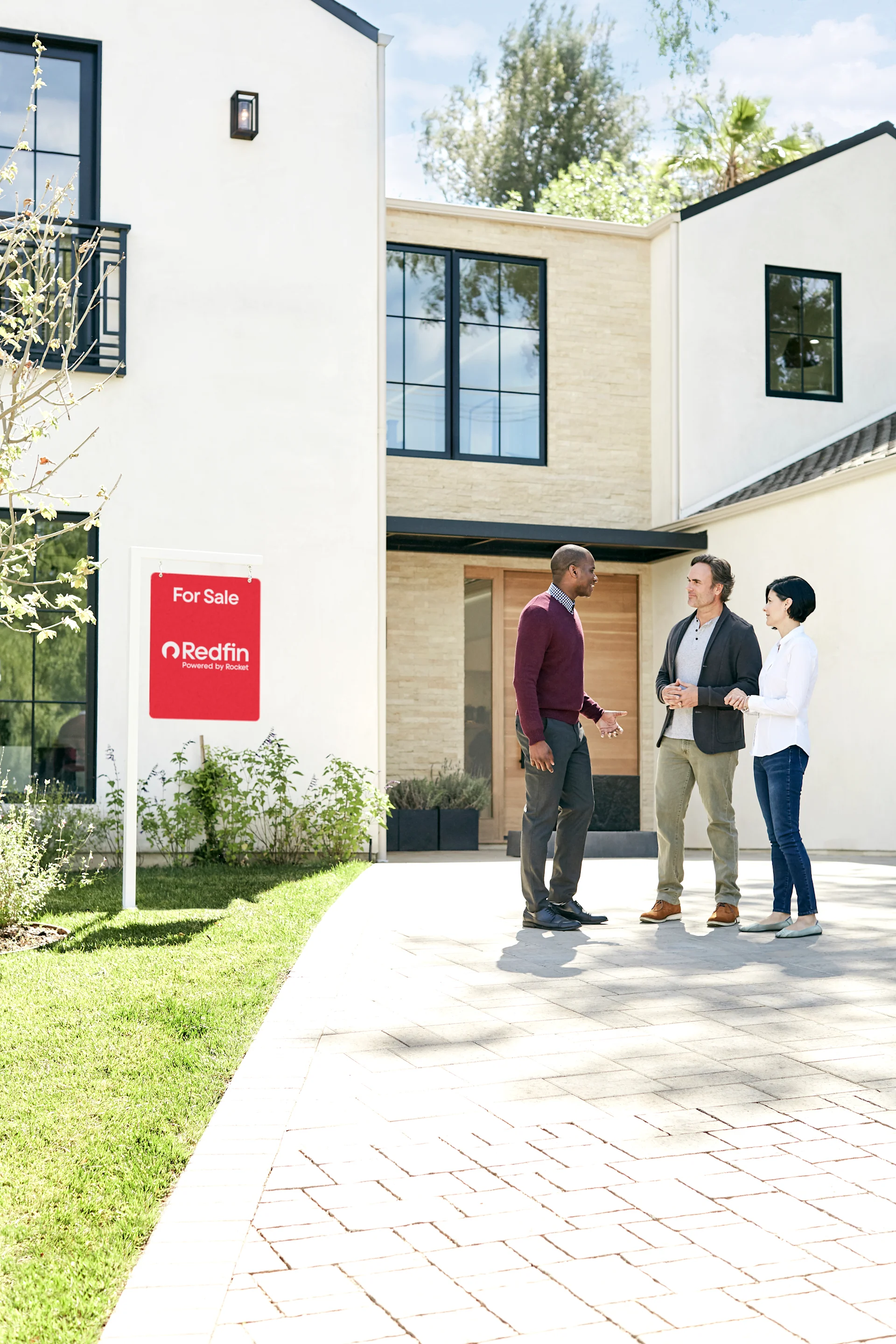 An image of a couple and their real estate agent at a Redfin property