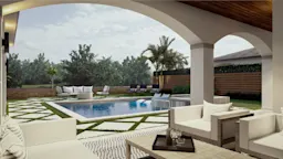 Covered patio with cushioned lounge seating overlooking a backyard pool, featuring geometric stone and grass pavers, outdoor furniture, and palm trees along a wooden fence.