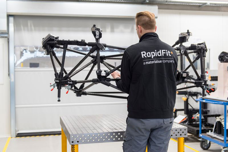 A RapidFit employee lifts a lightweight aluminum fixture.