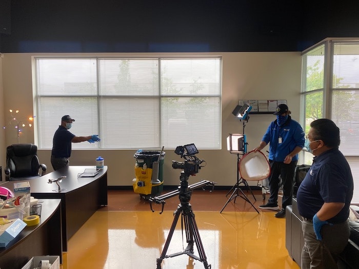 camera crew recording janitor clean office.