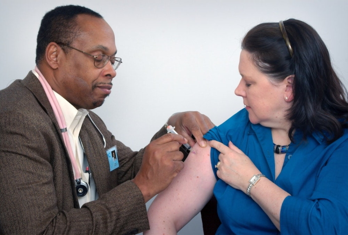 doctor giving woman a flu shot.