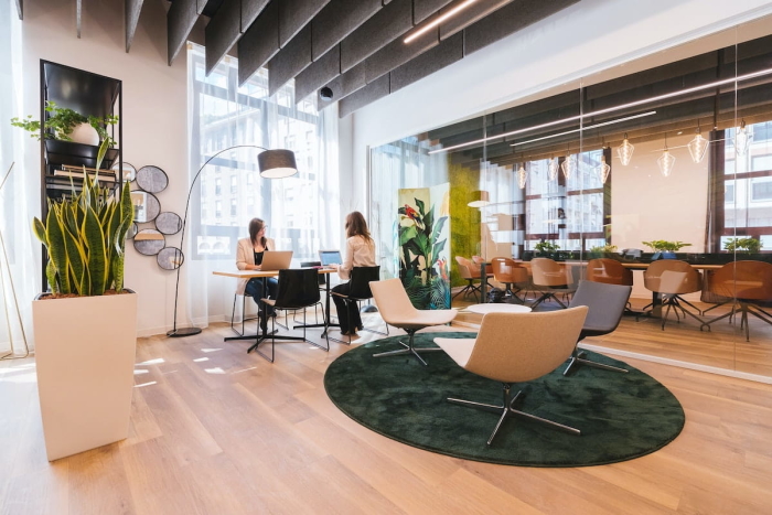 Two women sitting in clean, open space office.