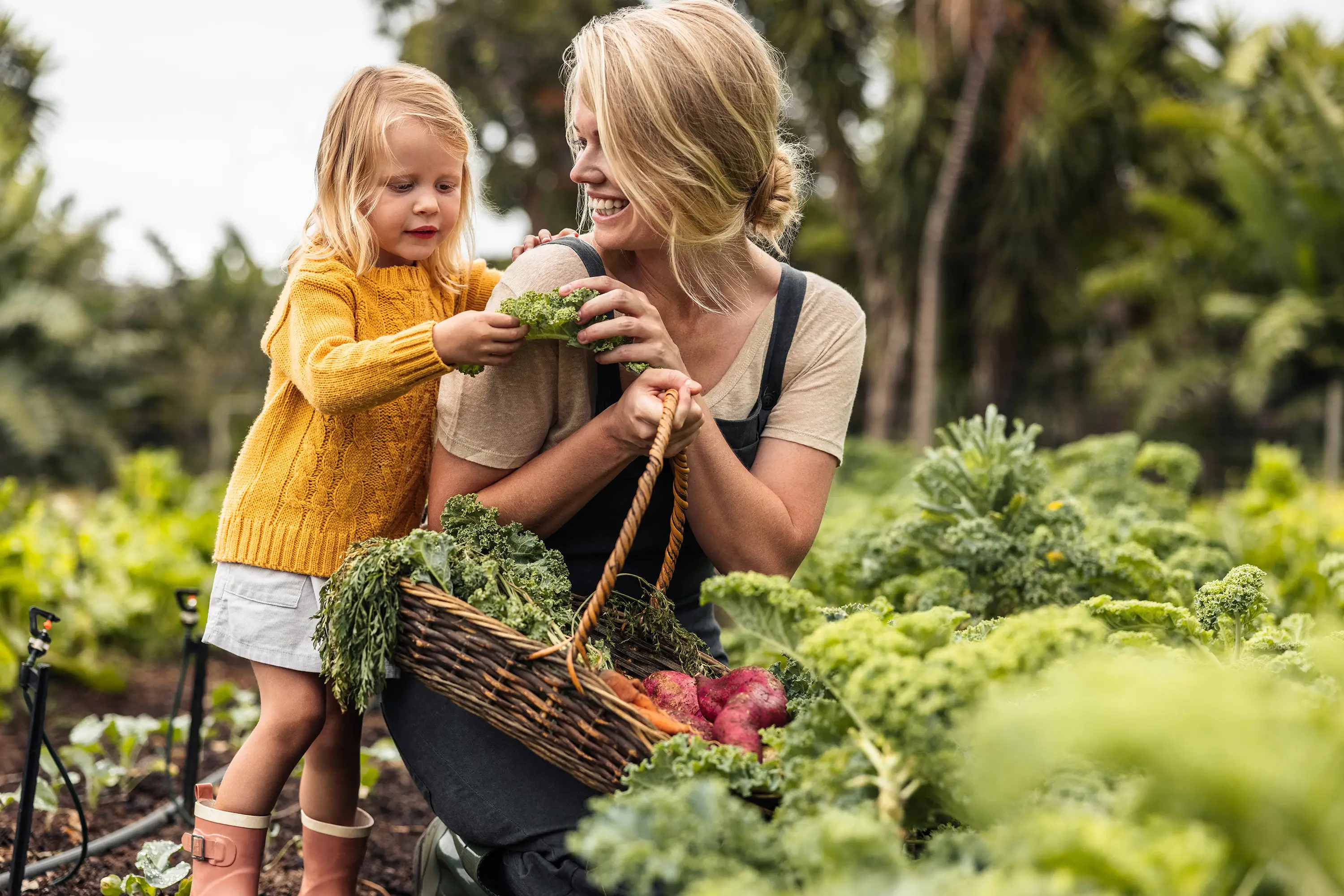 Mother gathering vegetables with daughter