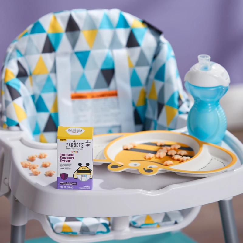 Zarbee's Baby Immune Support Syrup on a Baby Eating Chair