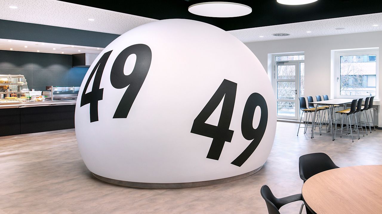 Bild einer großen LOTTO-Kugel, die in einer Cafeteria platziert ist.