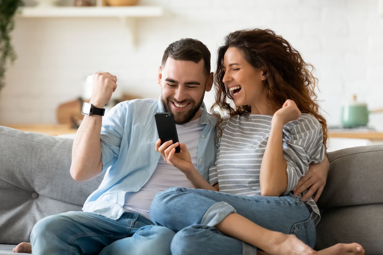 Fröhliches Pärchen hält Smartphone