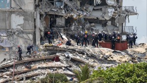 Members of the South Florida Urban Search and Rescue team look for possible survivors in the partially collapsed 12-story Champlain Towers South condo building