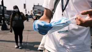 Members of the Test and Trace Corps walk the streets of Brooklyn passing out masks