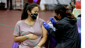 A pregnant woman gets a COVID-19 vaccine booster.