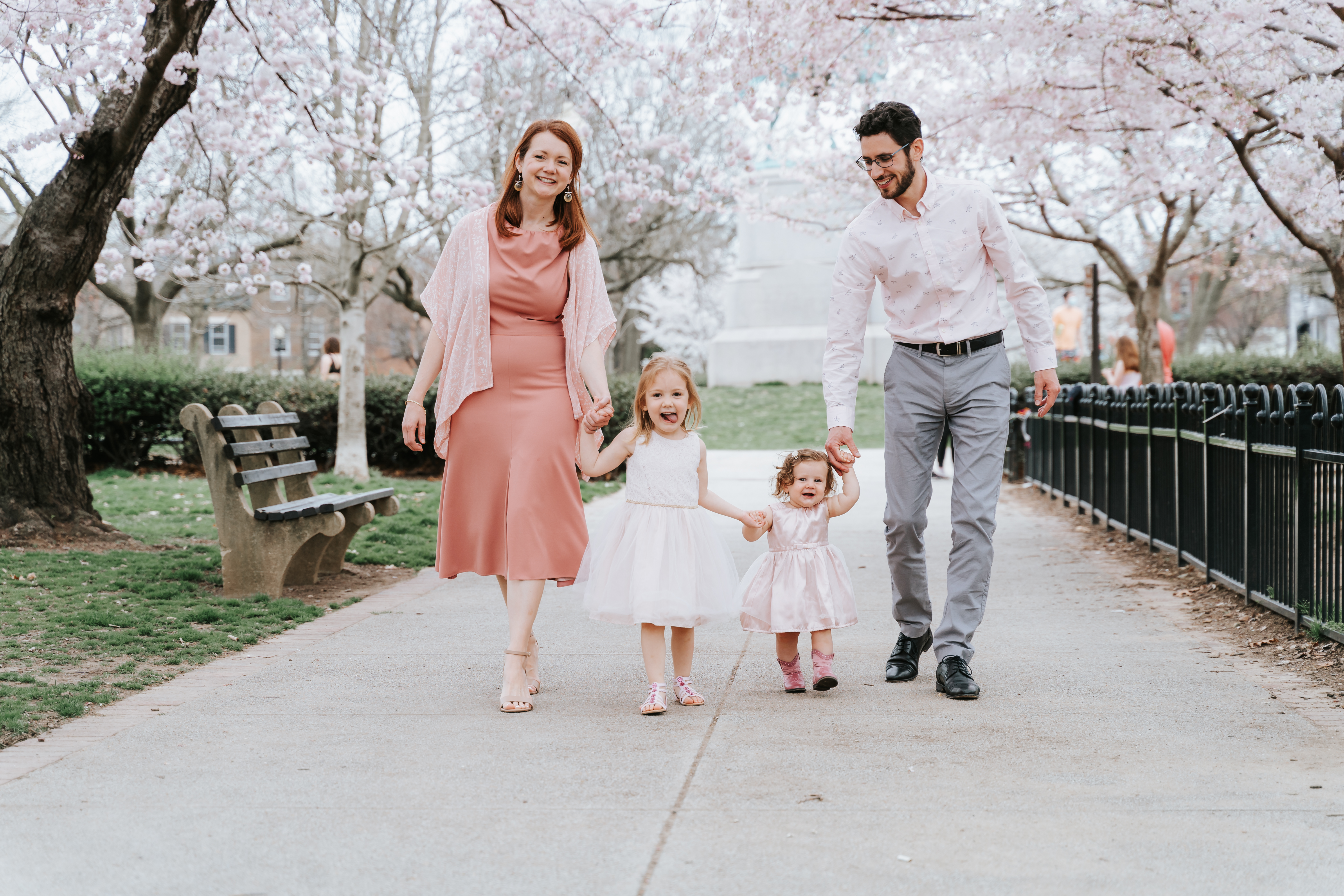 Spring Shoott family photos with pastel outfits among cherry blossoms.