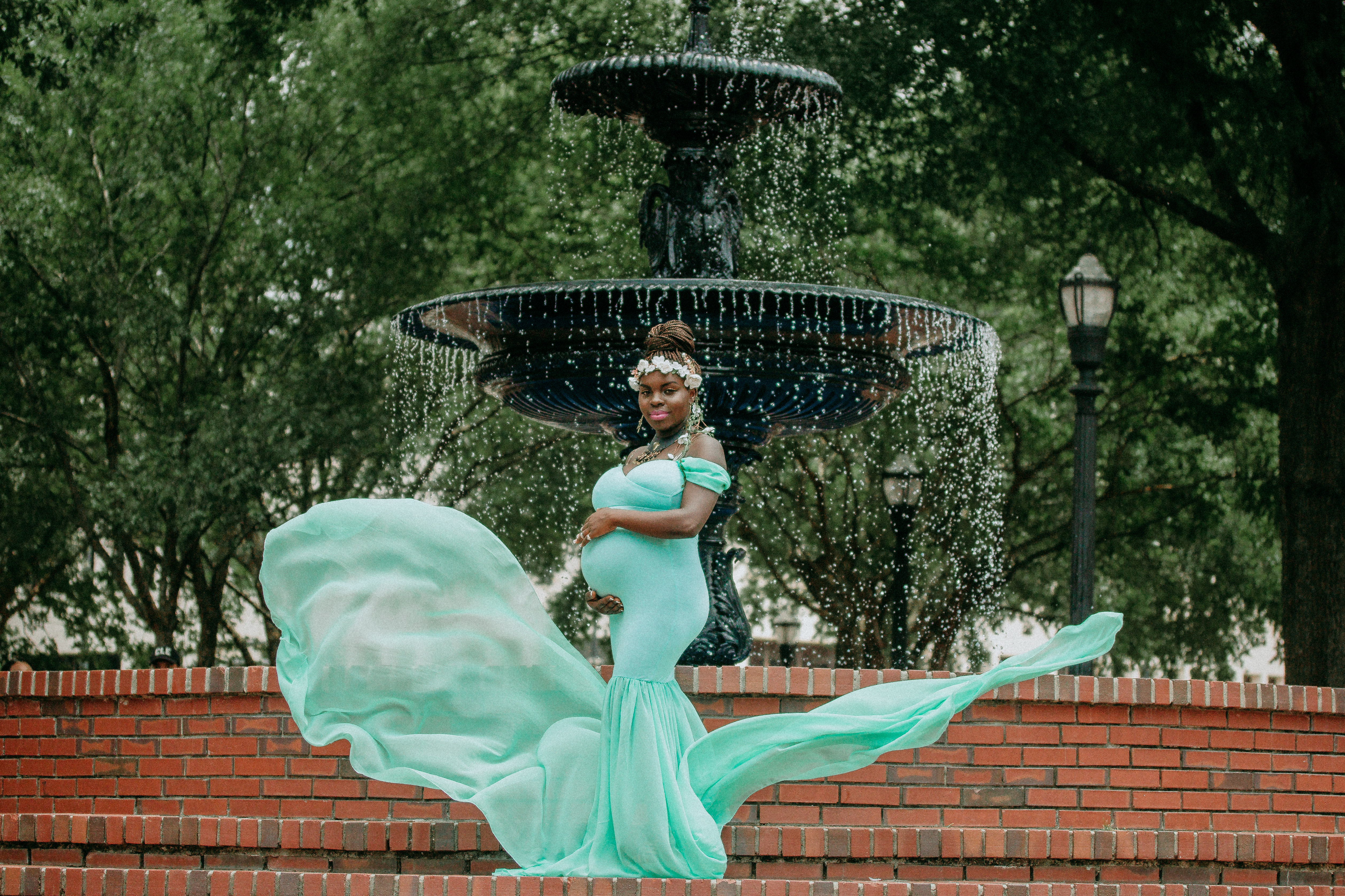 Expectant mother during a maternity photoshoot on the brick sidewalks of Marietta Square in Atlanta, captured by a Shoott photographer.