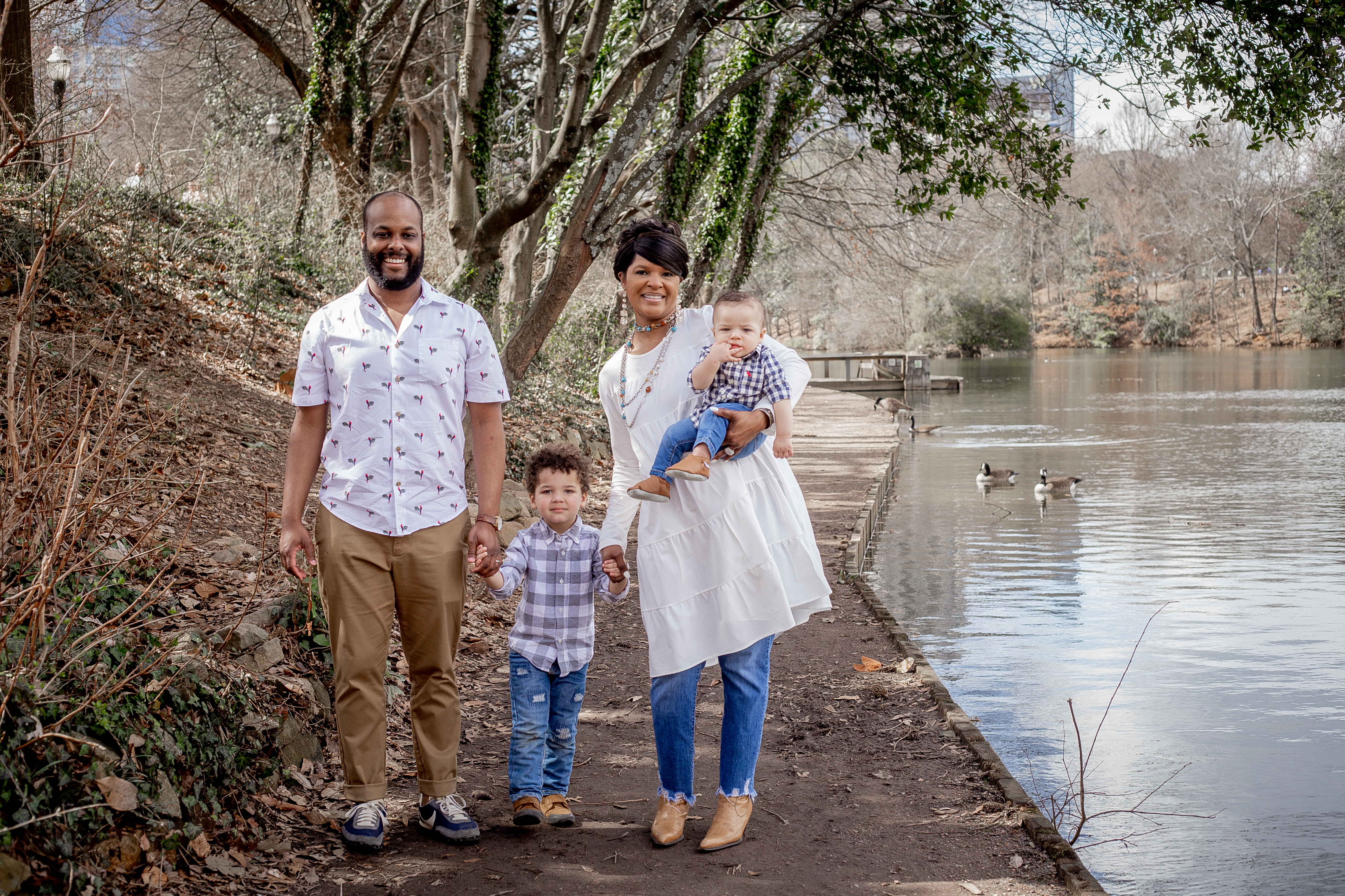 Family walking the tree-lined promenade near the Park Drive Bridge at Piedmont Park by a Shoott photographer.