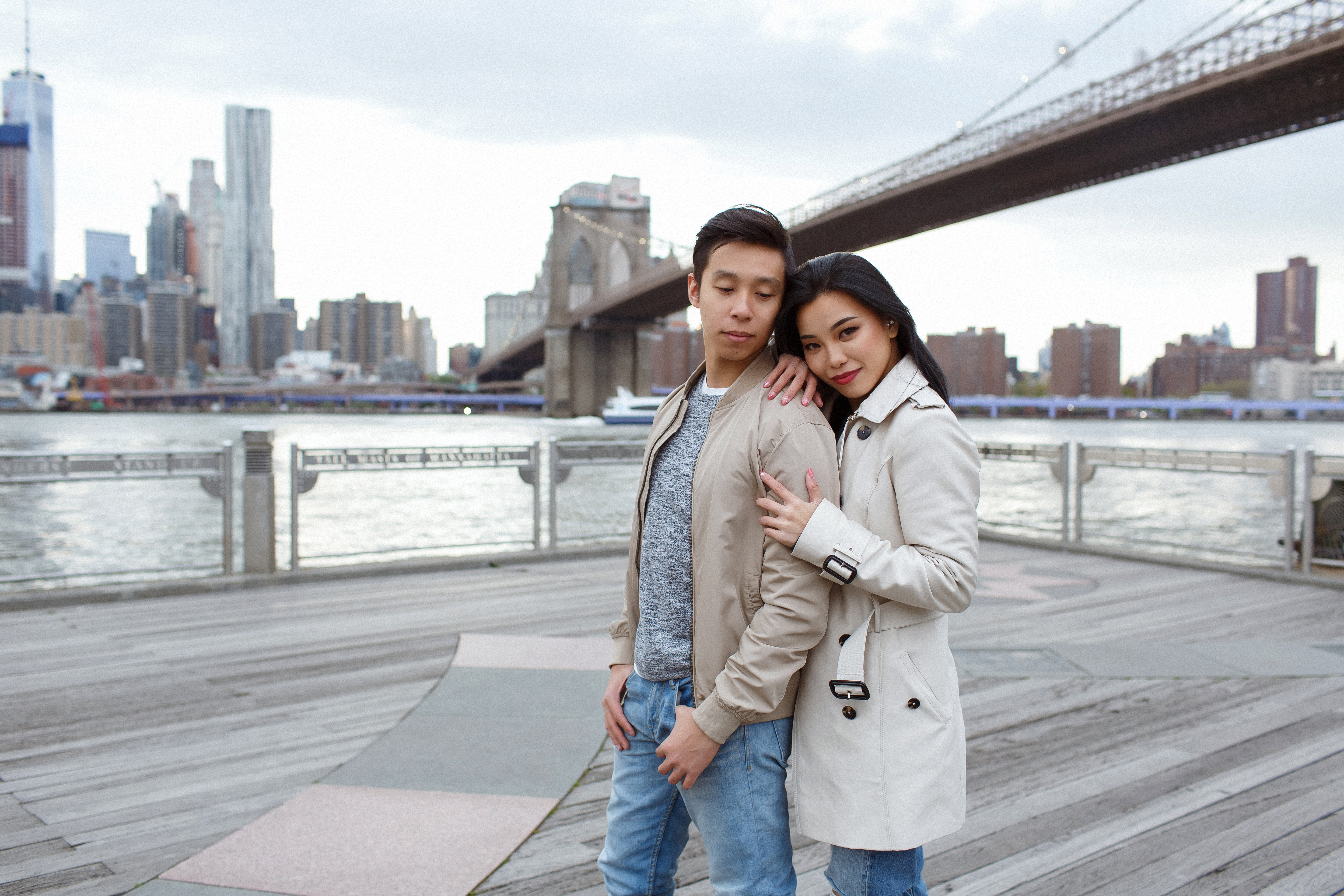 Couple posing for a free Shoott traditional portrait photography session on a waterfront with a city skyline