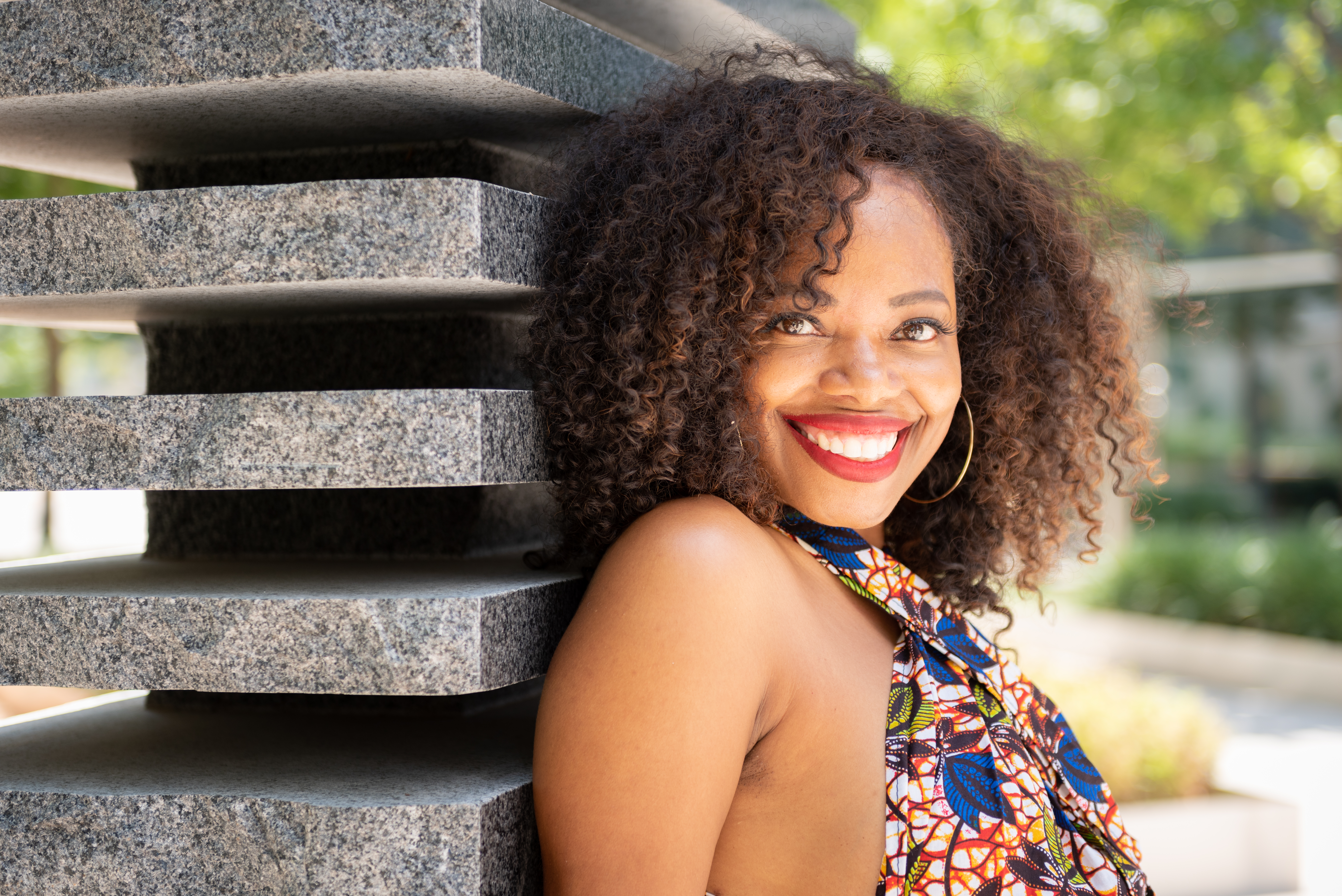 Woman smiling confidently outdoors during a free Shoott professional portrait photography session
