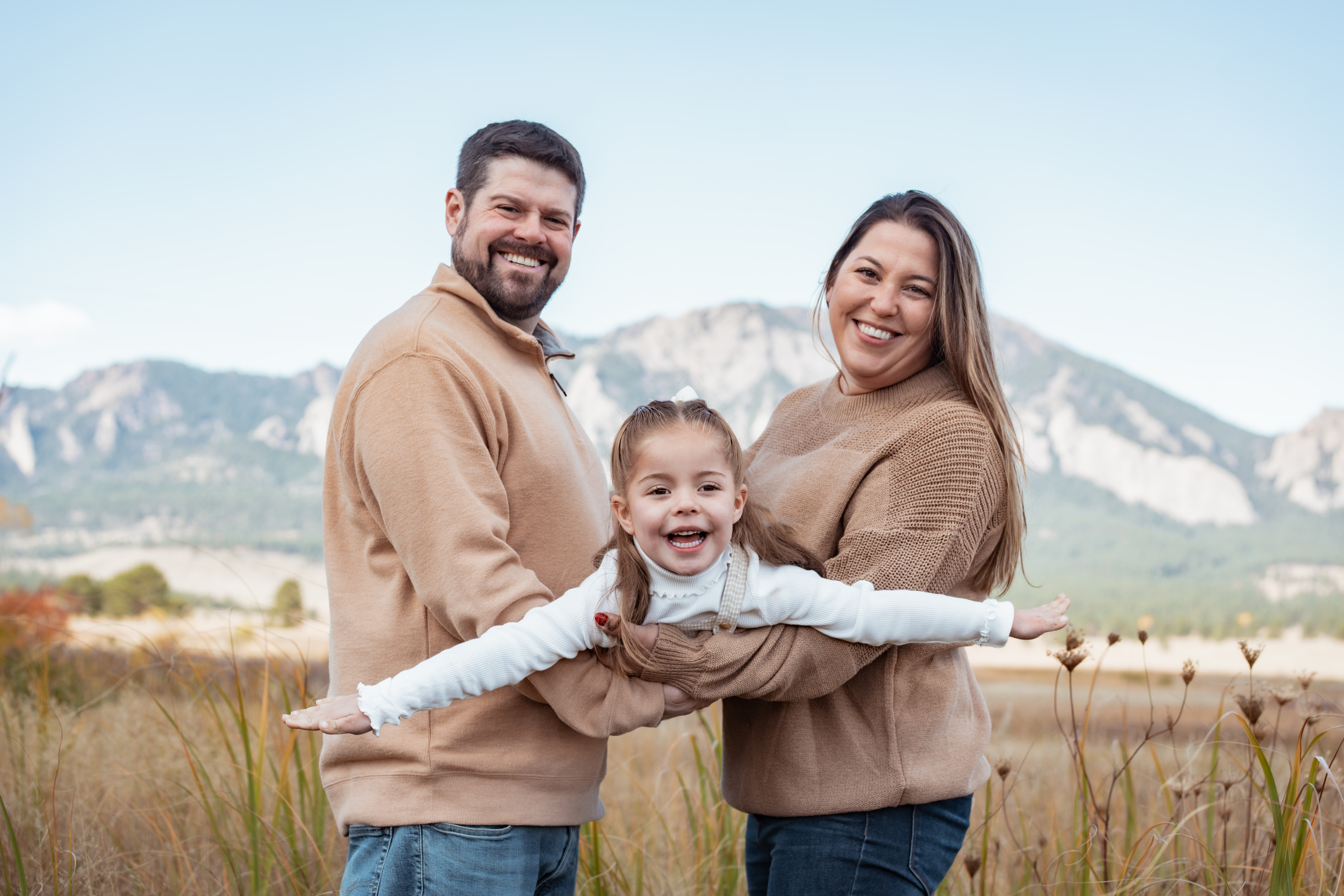 Child wearing a comfortable layered outfit during an outdoor fall family photoshoot