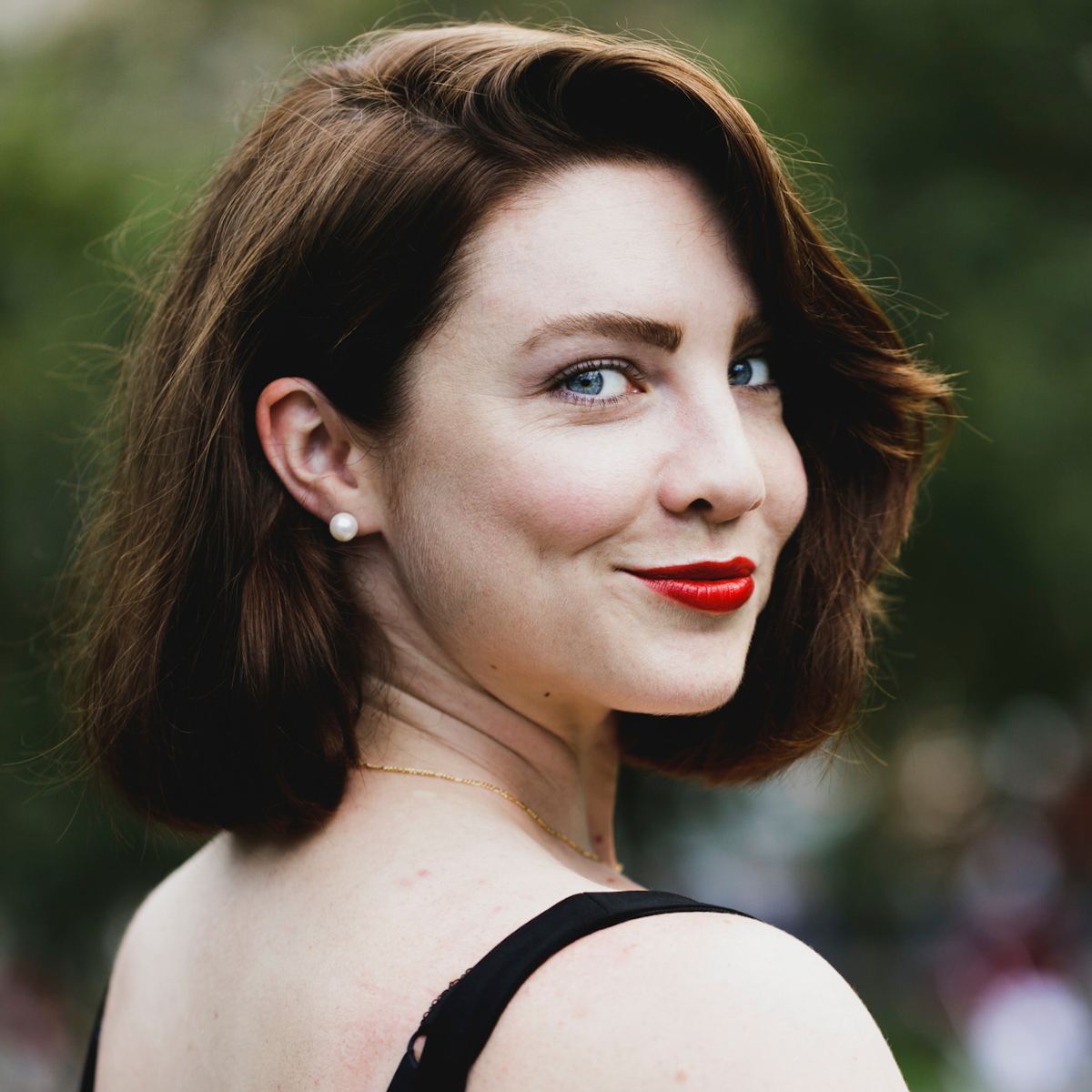 Woman smiling in natural light during a free Shoott dating profile photography session, outdoor portrait close-up