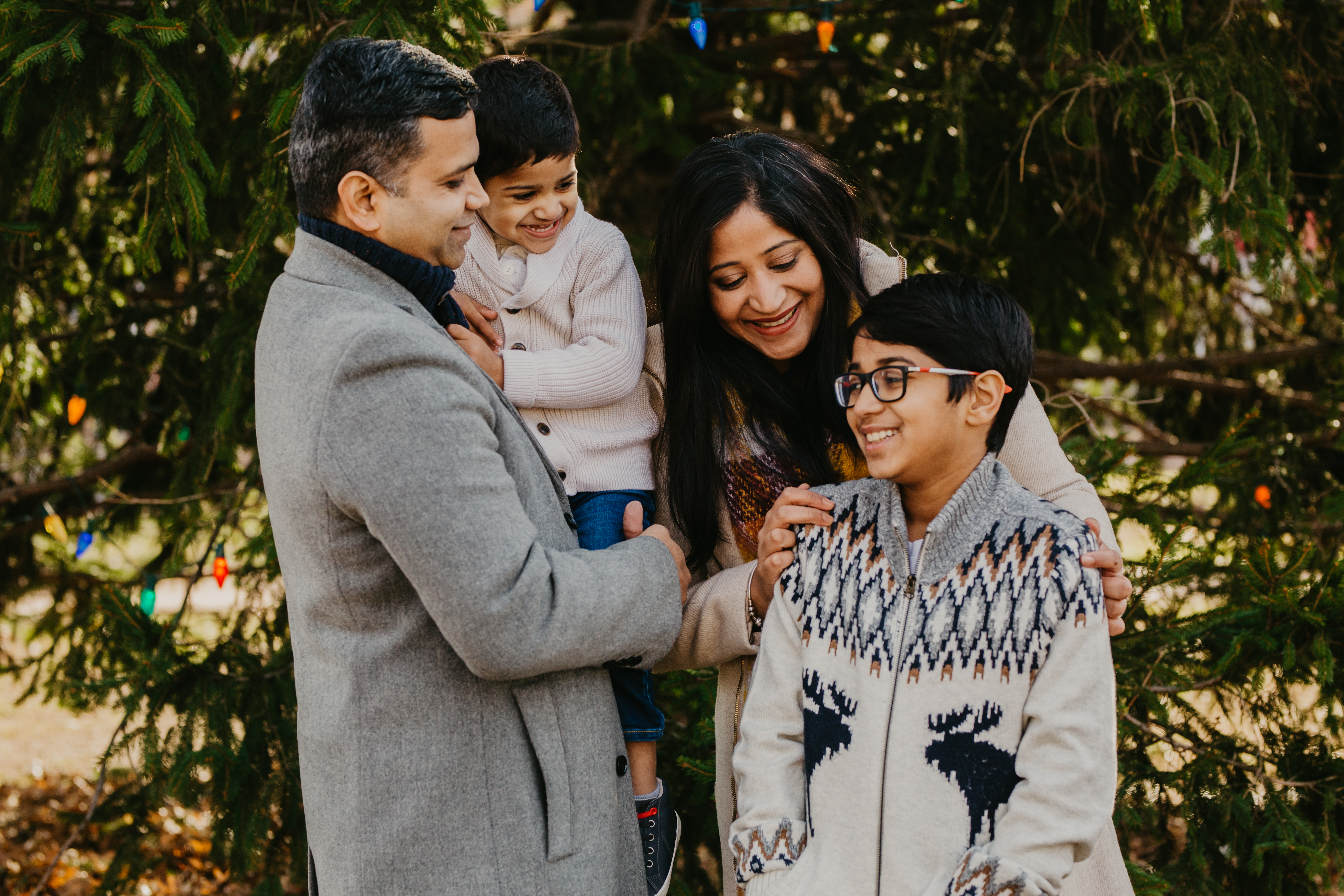 Family in coordinated winter outfits during an outdoor Christmas photoshoot

