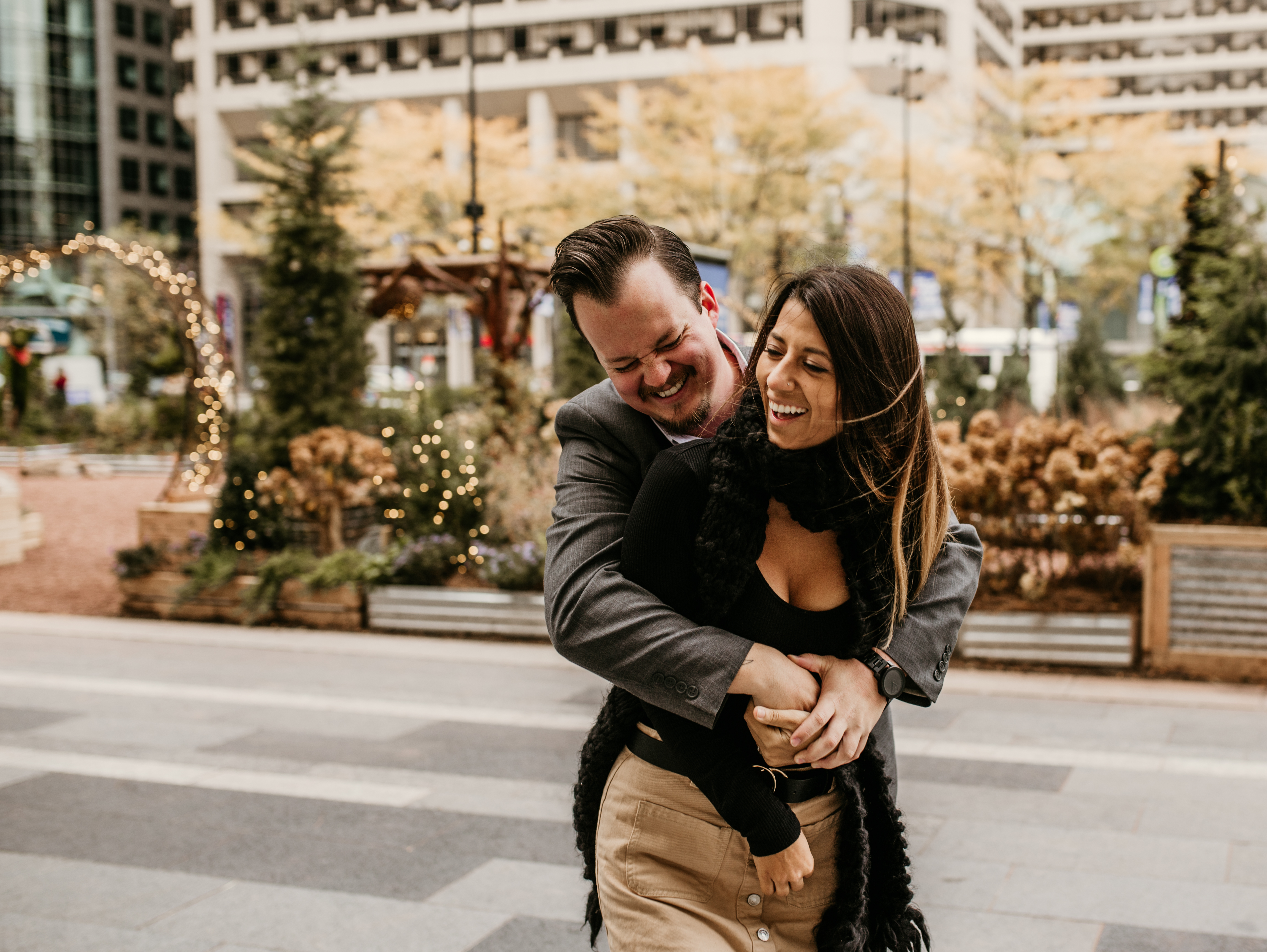 Couple laughing together during a free Shoott lifestyle photography session with city lights in the background