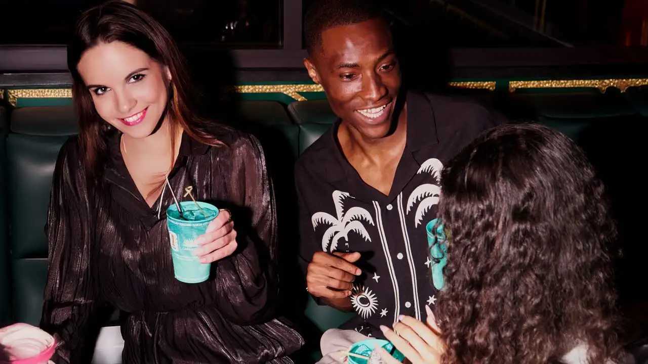 Three friends at a Lucky Strike center drinking cocktails.