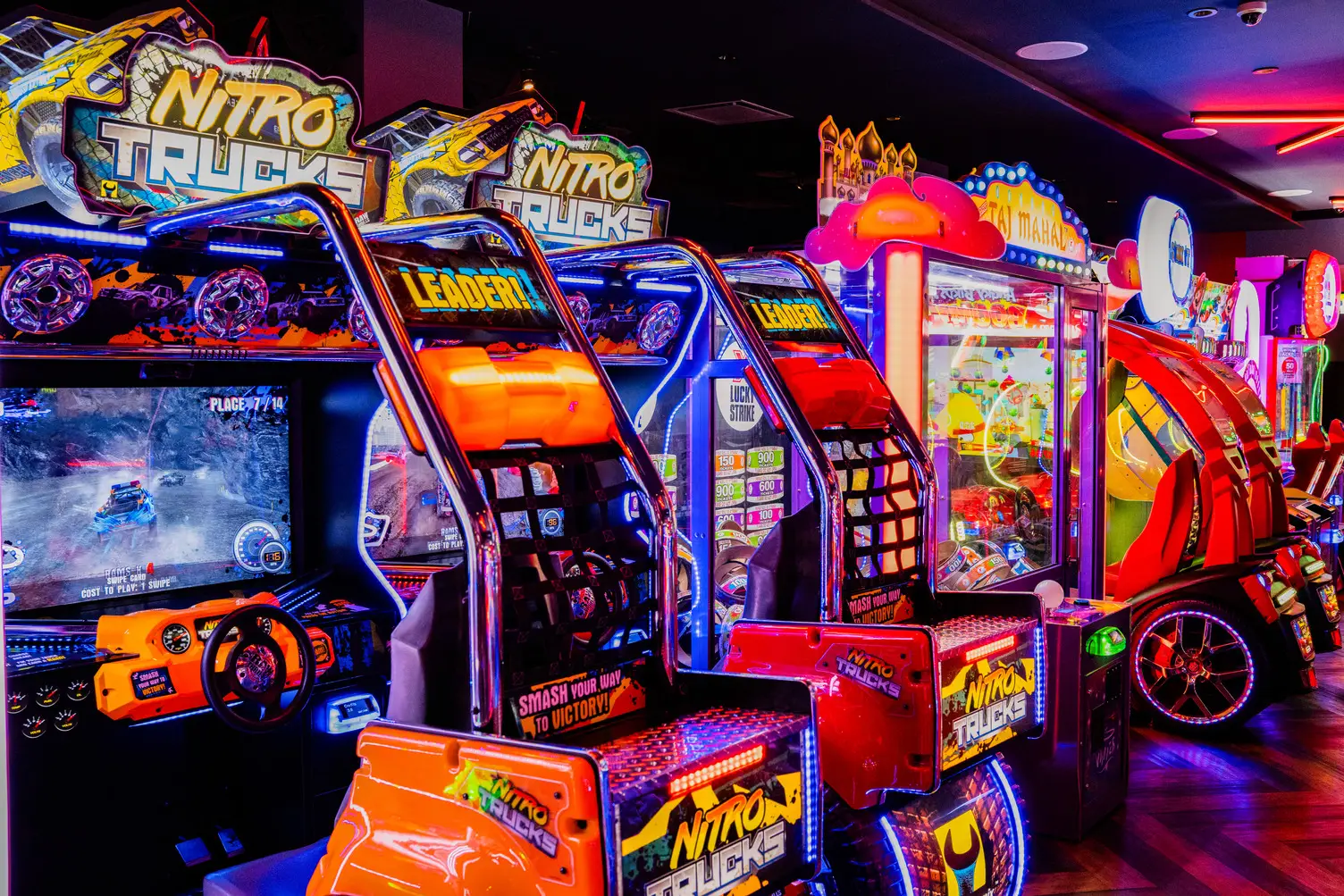 Nitro Trucks and claw machine arcade games glowing in neon at Lucky Strike Times Square
