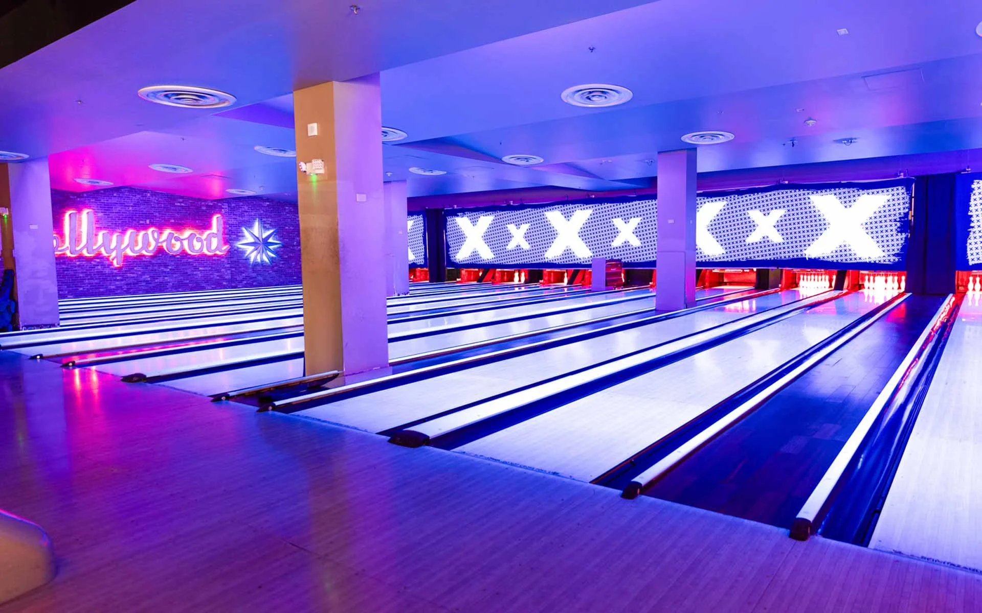 Expansive Lucky Strike bowling lanes with LED lighting, large digital screens, and sleek modern design for a premium bowling experience.