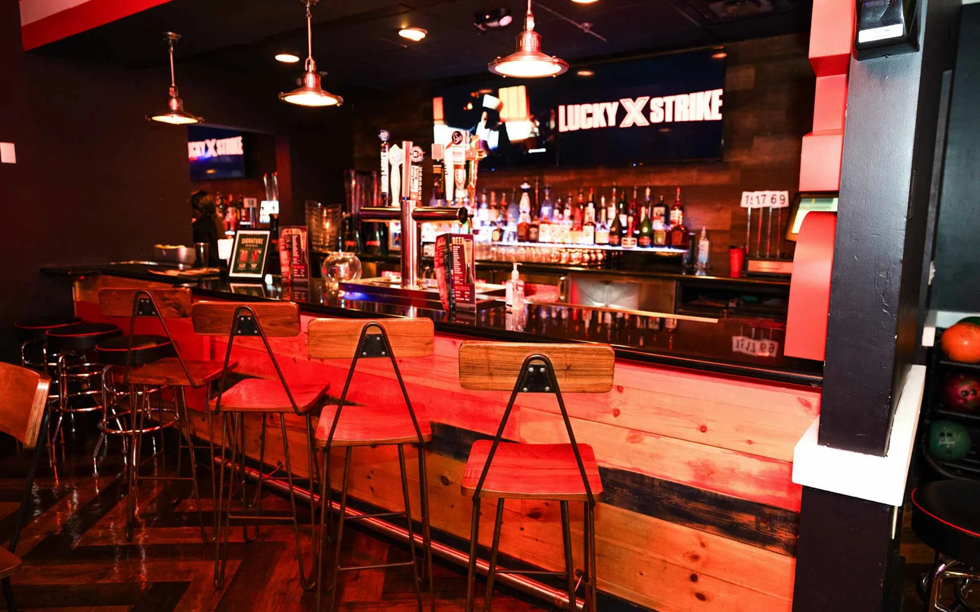 Lucky Strike bar with wood finishes, craft beer taps, liquor display, and modern seating in a stylish nightlife setting