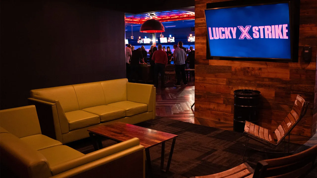 Comfortable and private lounge with cushioned couches and a large TV screen