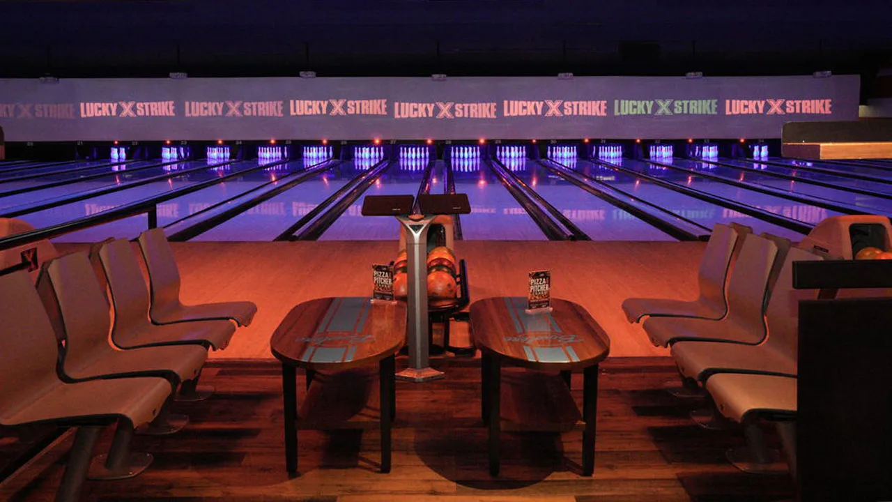 Beautiful bowling lanes with black lights and large TV screens above the lanes